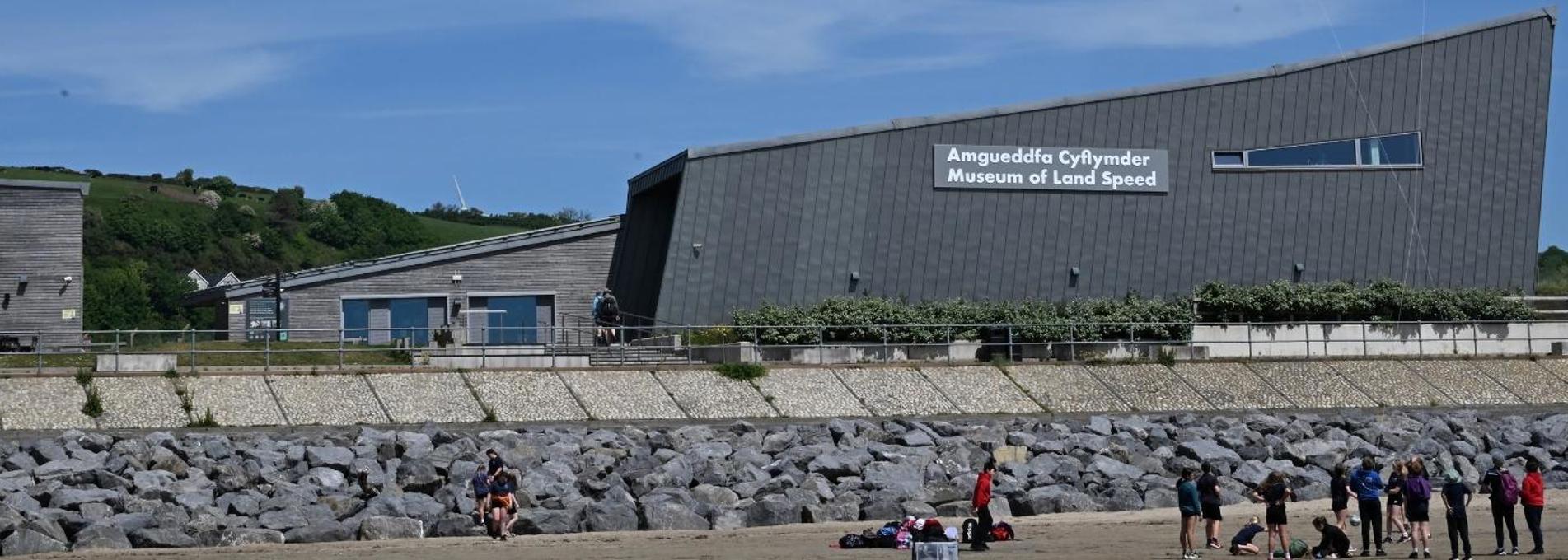 Large, grey building (the Museum of Land Speed) overlooking a beach