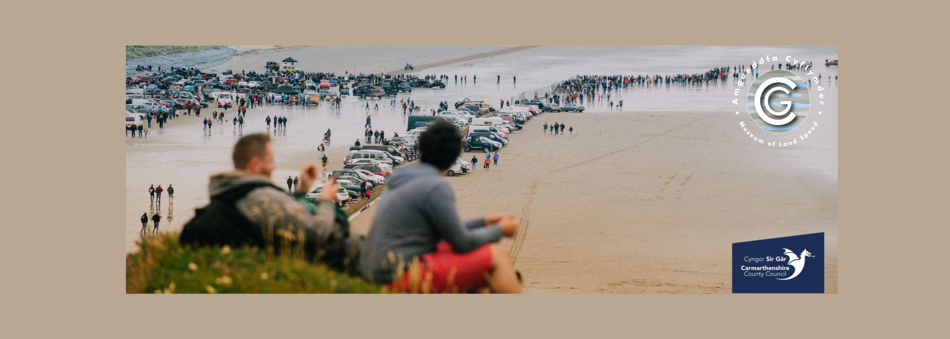 Two people watching the Vintage Hot Rods gather on Pendine Sands